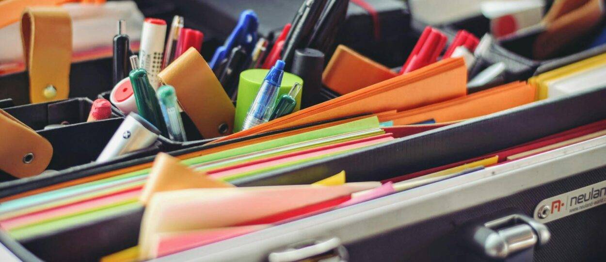 A collection of colorful office supplies neatly arranged in a suitcase, perfect for professionals on the go.